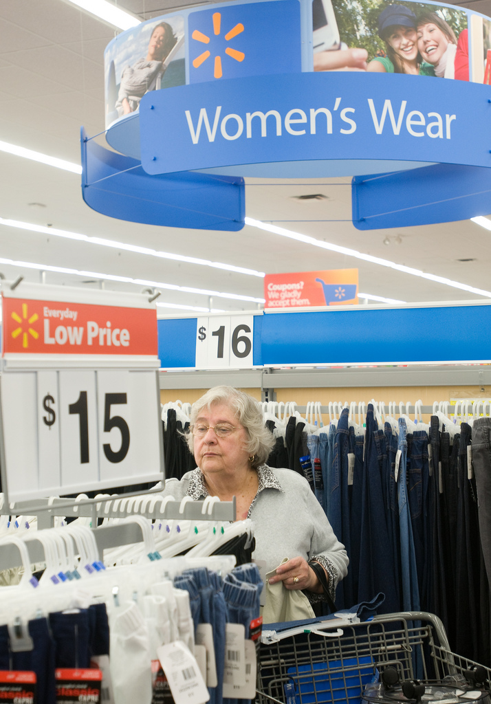 Auf dem Bild ist eine Frau in einem Einkaufsladen zu sehen. Sie schaut sich Kleider an.