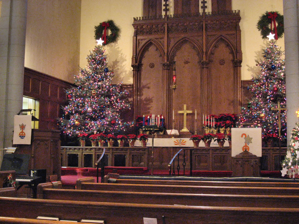 Auf dem Bild sind Weihnachtsbäume in einer Kirche zu sehen