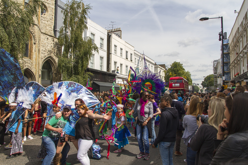 Auf dem Bild sind verschiedene Menschen bei der Notting-Hill-Karneval Feier zu sehen