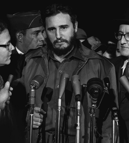 Auf dem Bild ist Fidel Castro zu sehen. Vor ihm sind Mikrofone aufgebaut.