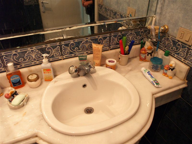 Auf dem Bild ist ein Waschbecken und verschiedene Hygiene-Sachen zu sehen
