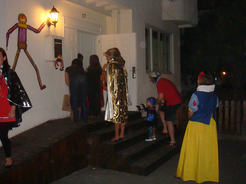 Auf dem Bild sind Personen bei einem Halloween Brauch zu sehen (Süßes oder Saures)