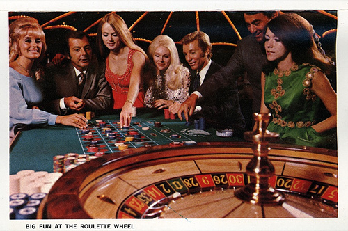 Auf dem Bild sieht Personen an einem Roulette-Tisch